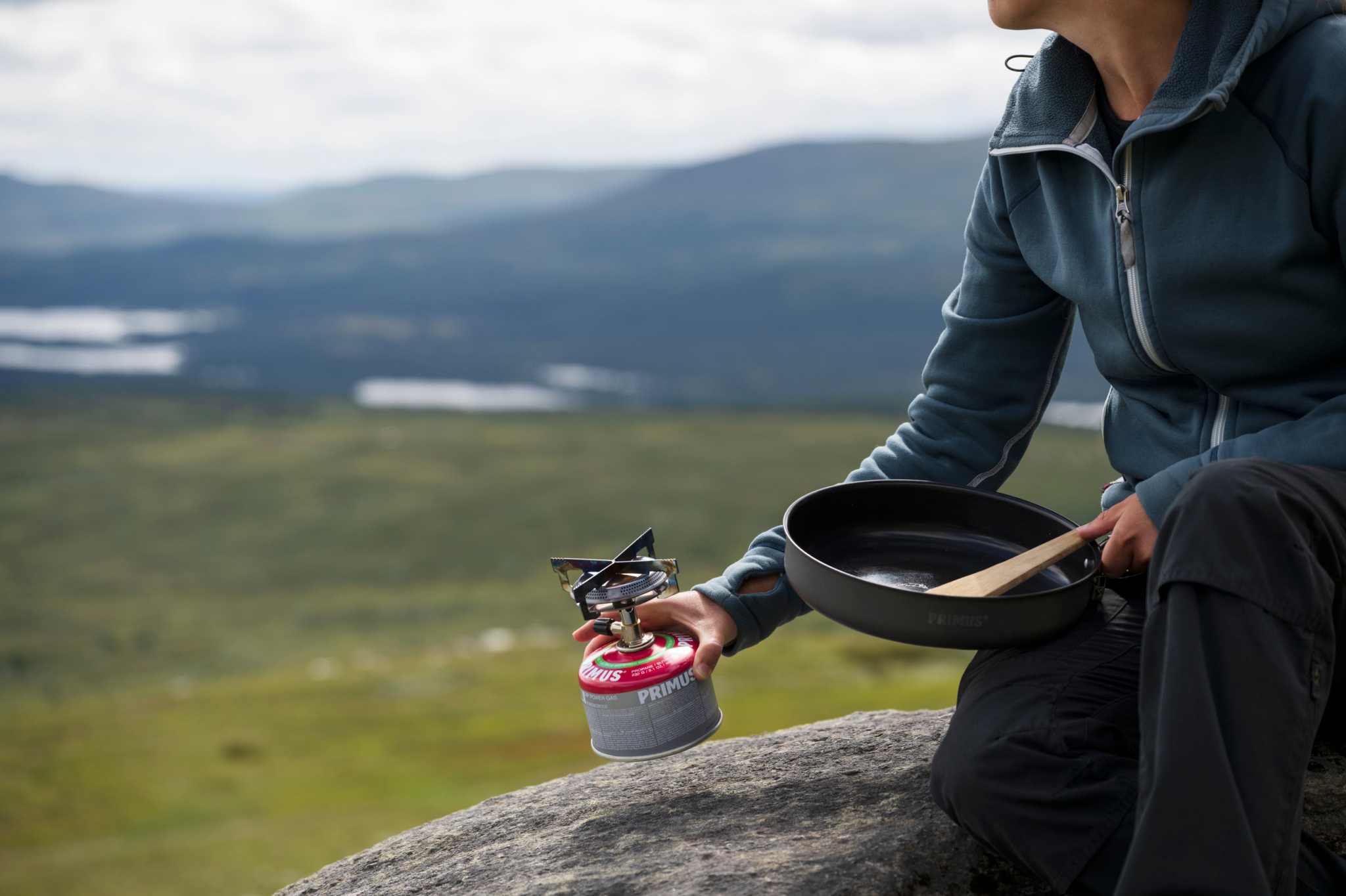 Gaskök Mimer Backpacking Stove i metall med röd gasbehållare, fyra kärlstöd och bred brännare för friluftsmatlagning.