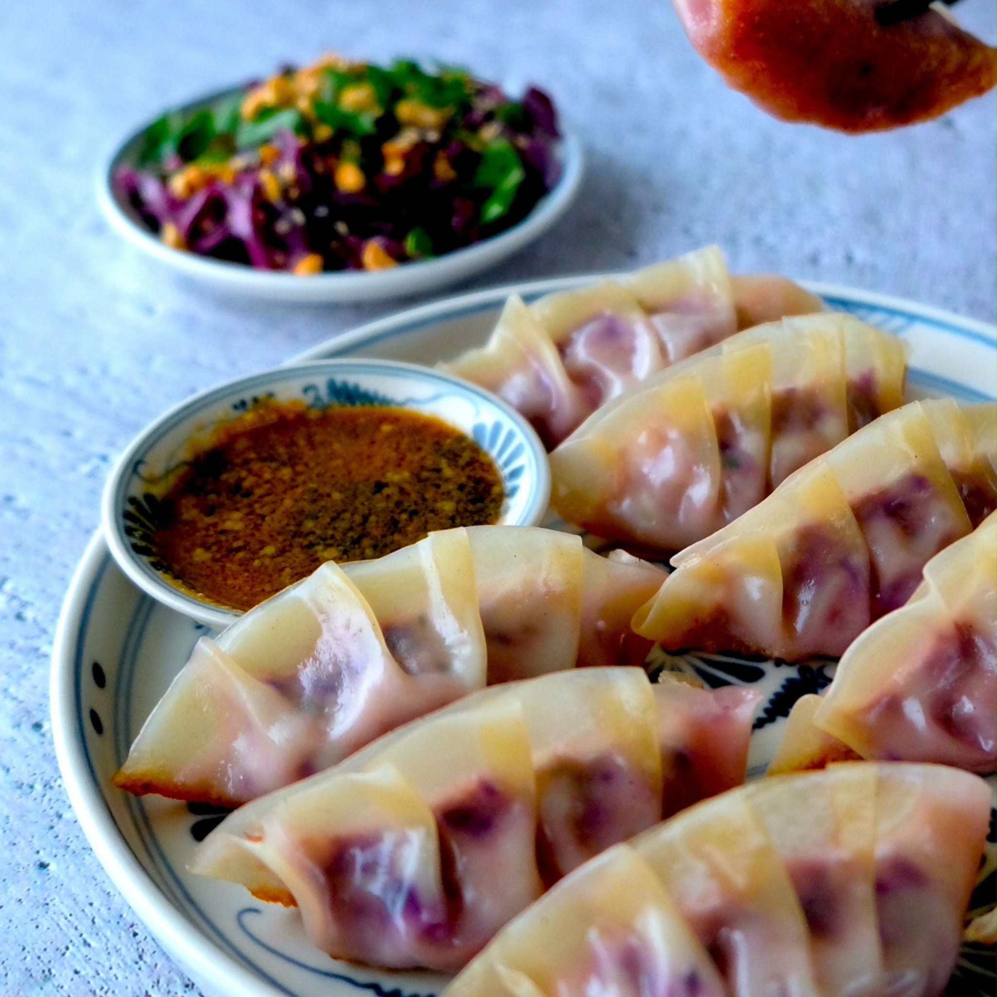 Kokbok för Stekhäll med recept på maträtter; bilden visar ljusa degknyten med fyllning och en skål dipsås.
