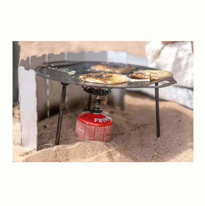 Gaskök i rostfritt stål med fyra kärlstöd och röd gasbehållare; Mimer Backpacking Stove används med stekhäll.