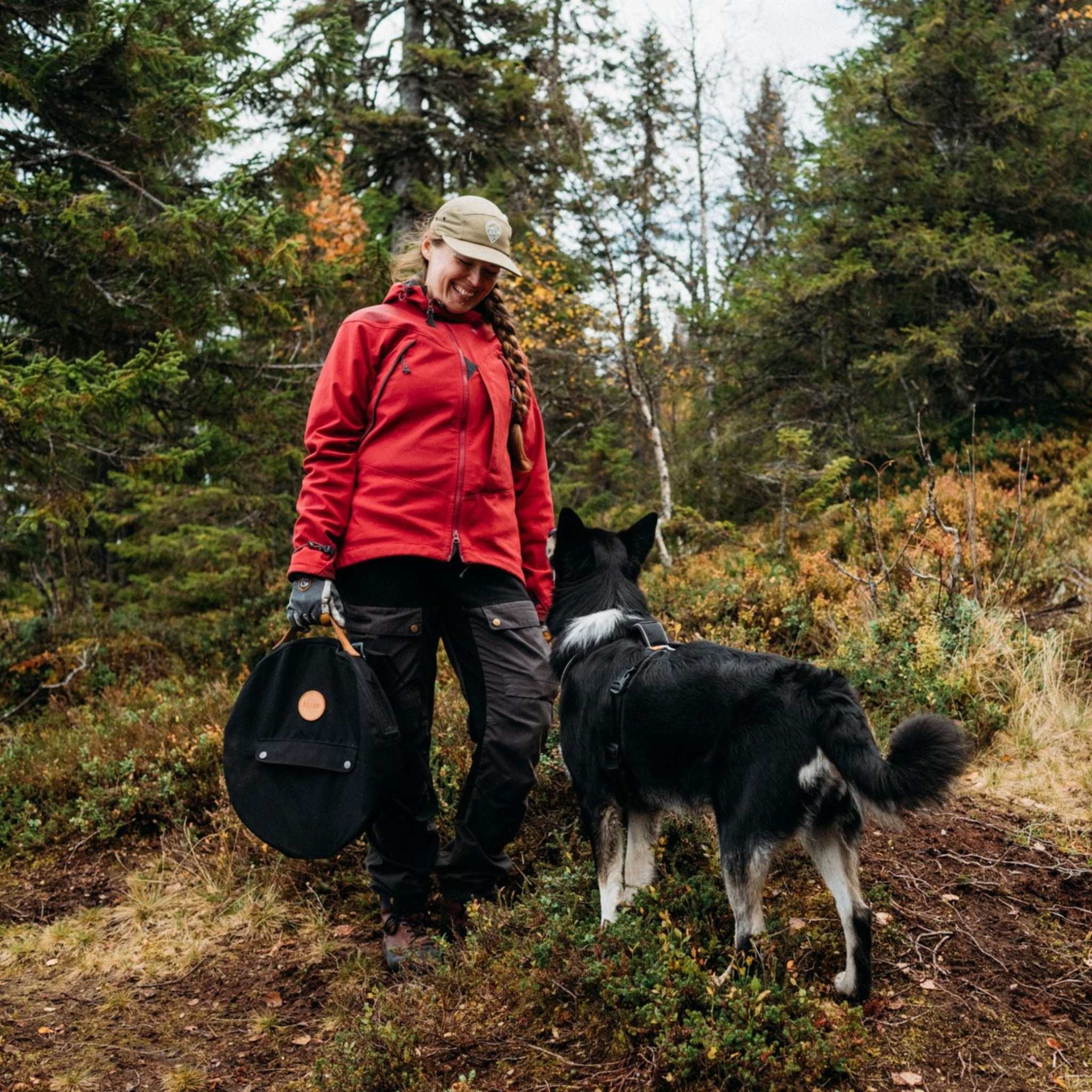 Stekhäll Jälda carry kit med svart, rund transportväska i kraftig textil och bruna läderdetaljer, buren i handen.