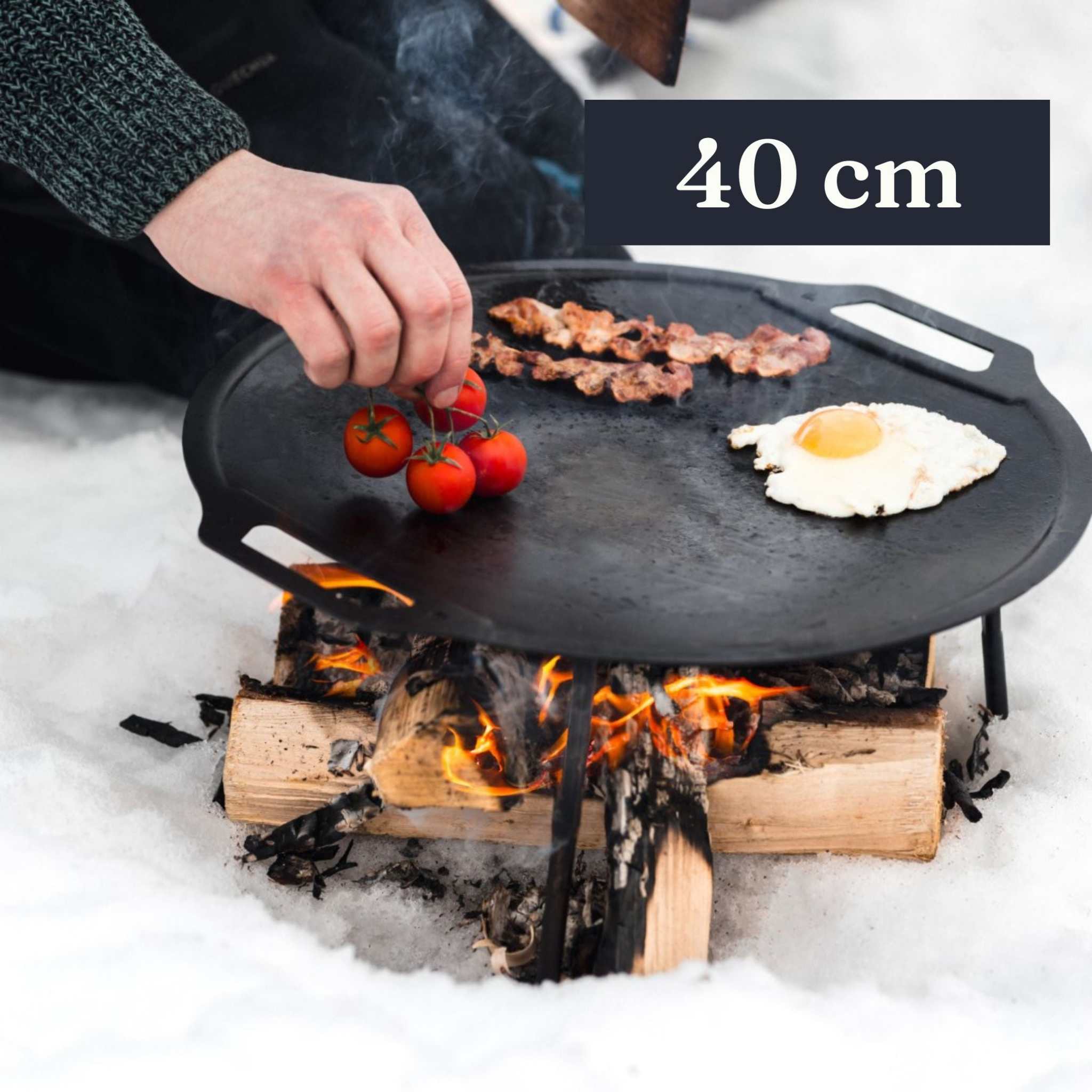 Dalum stekhäll i svart kolstål, rund med upphöjda kanter och avlånga handtag; 40 cm i diameter.